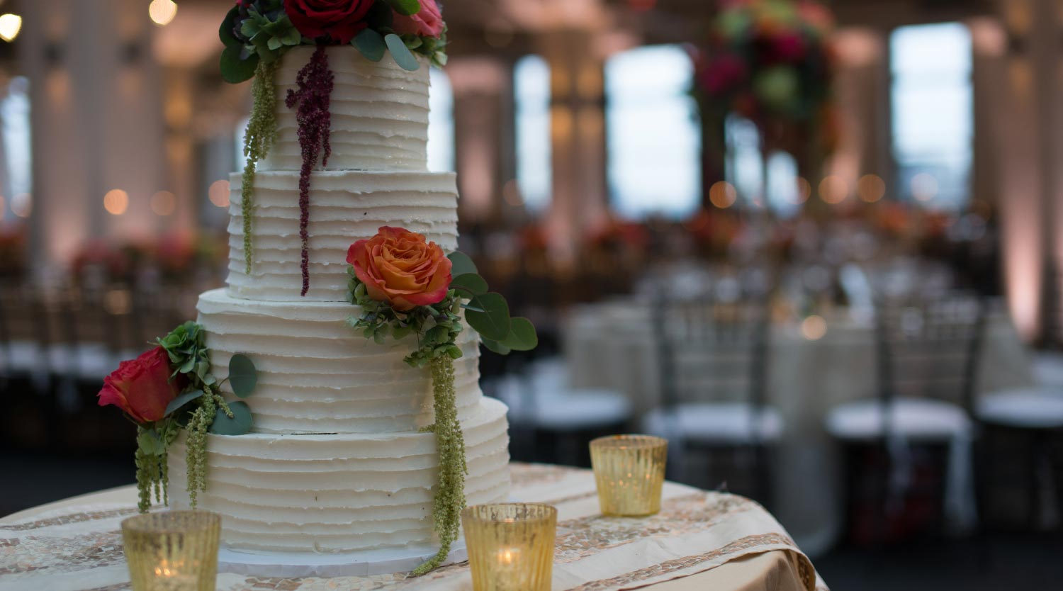 Photo: white frosted wedding cake with real flowers and hanging leaves