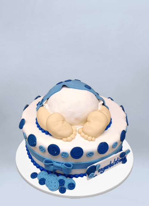 Photo: 1 tier cake with blue bows and buttons and baby butt and feet sticking out of top.