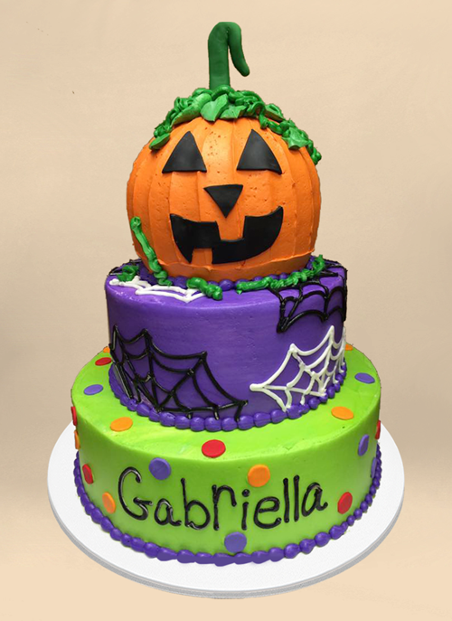 Photo: frosted green and purple cake with piped spider webs and large jack-o-lantern shaped top tier
