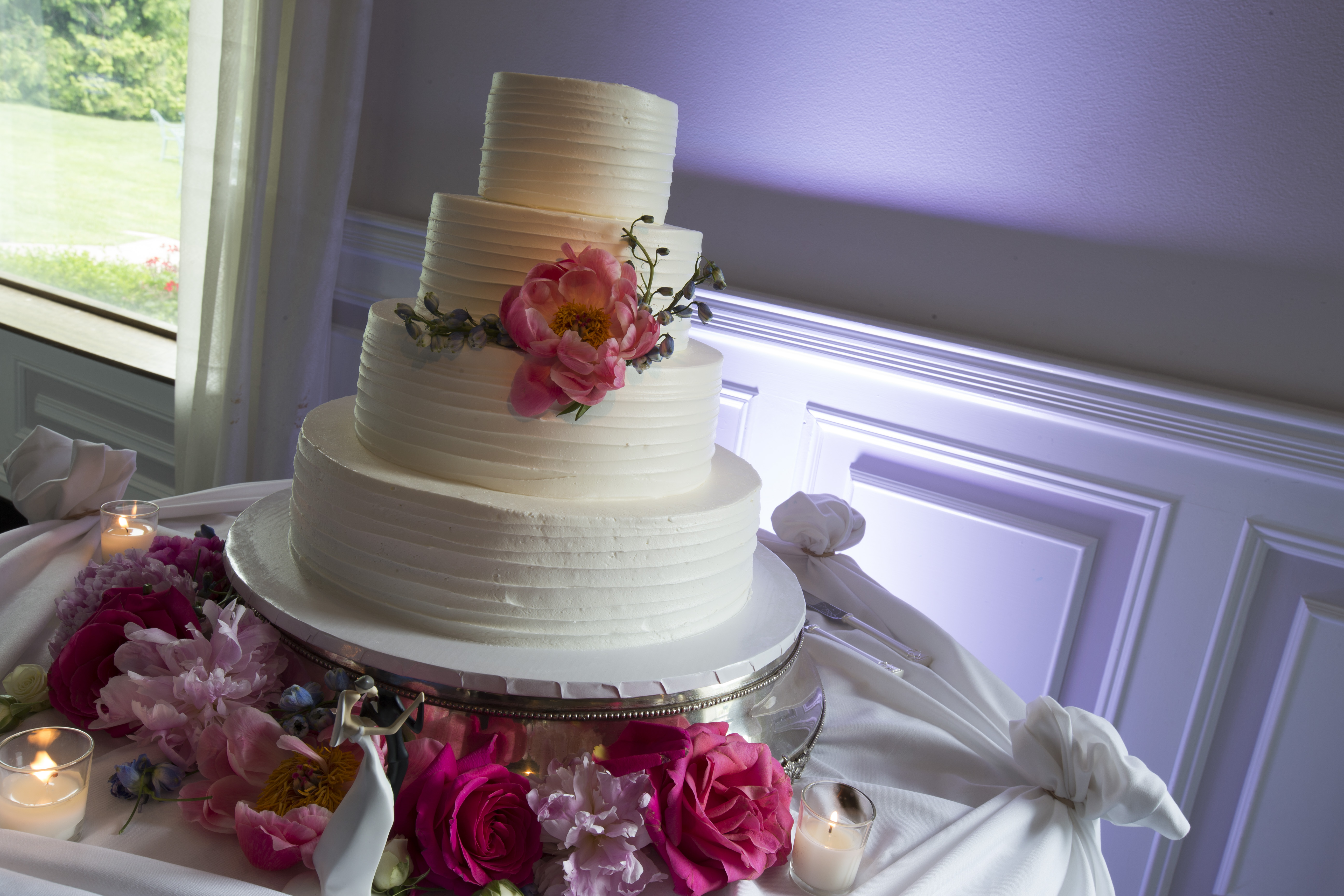 Photo: four tier clean white frosted cake with large pink flower