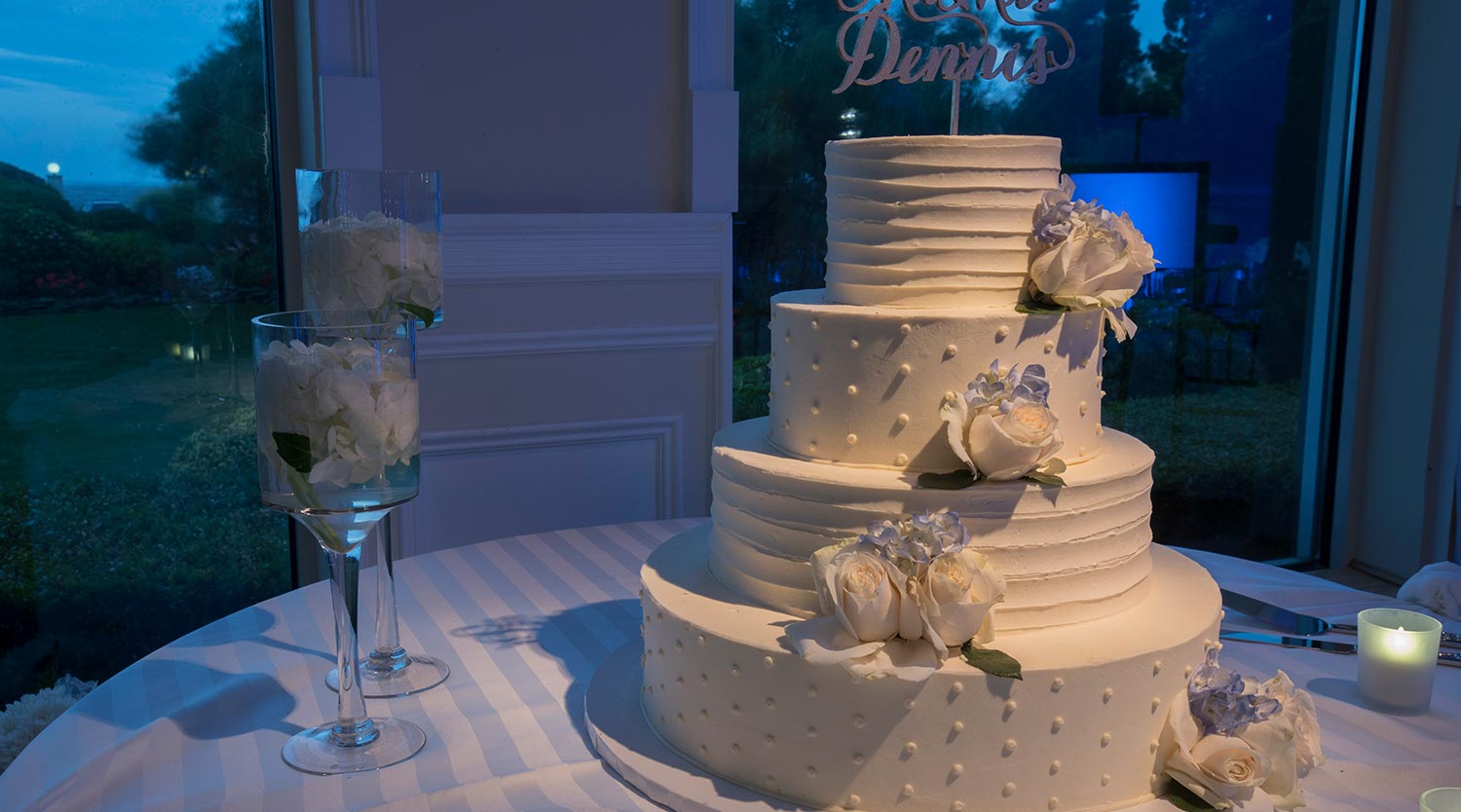 Photo: four tier wedding cake with alternating frosted pattern and white flowers