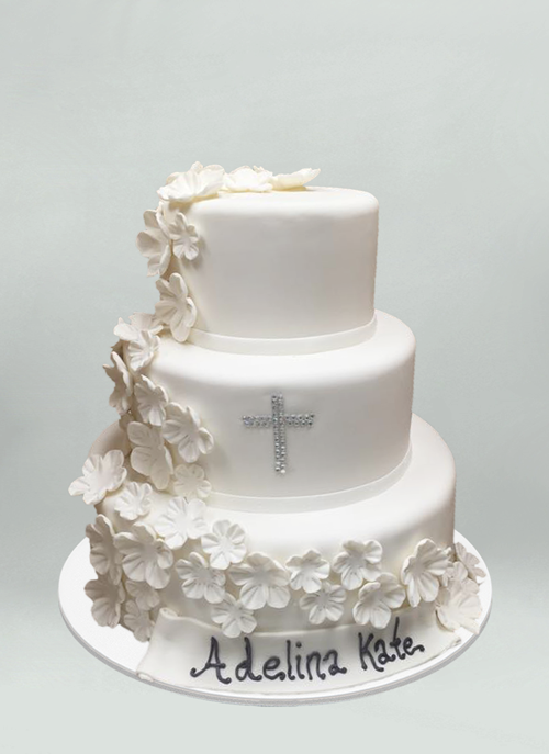 Photo: white fondant cake with cascading white sugar flowers and gem cross