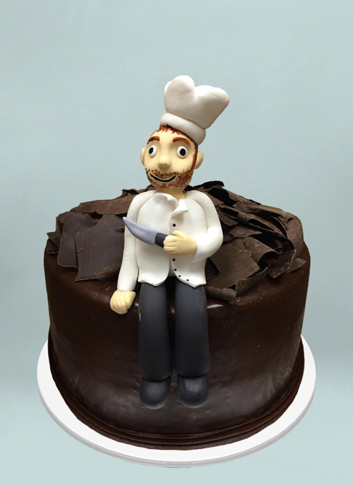 Photo: chocolate frosted cake with 3d fondant chef sitting on it