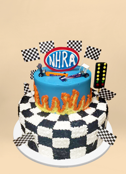 Photo: frosted cake with checkered pattern and flags, nascar cars on top