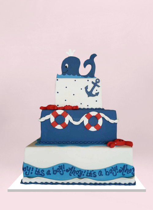 Photo: 3 square fondant tiers with with nautical elements and a smiling whale topper
