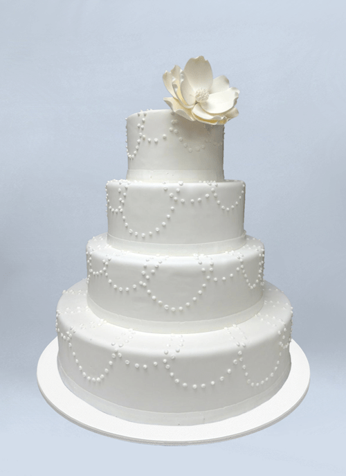 Photo: smooth white cake with drop bead patterns and fondant flower