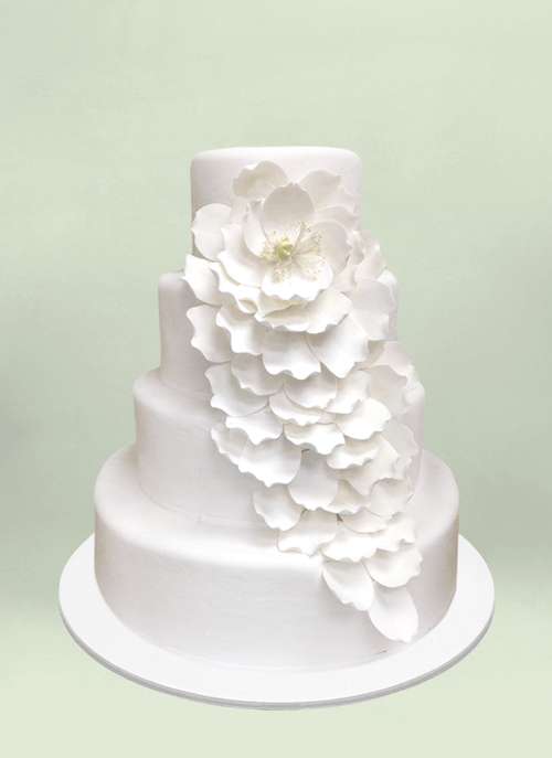 Photo: white cake with large flowing and leaves flowing down four tiers
