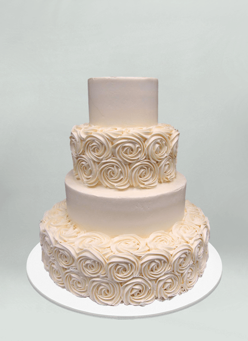 Photo: off white cake with large frosted flower pattern on alternating tiers