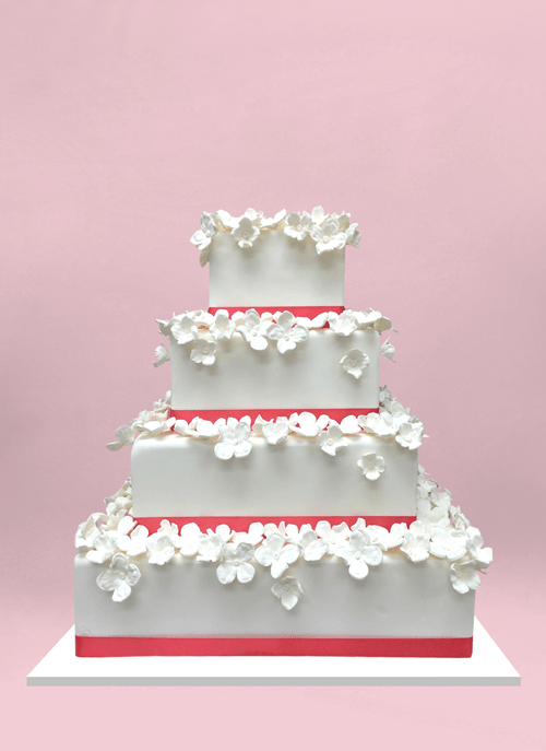 Photo: white square tiers with pink ribbon and small white flowers on each tier