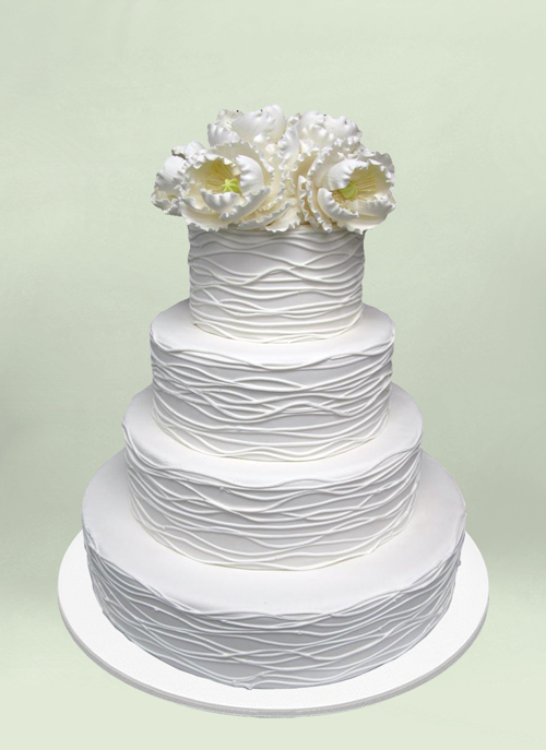 Photo: white wave frosting with overflowing white flowers on top tier