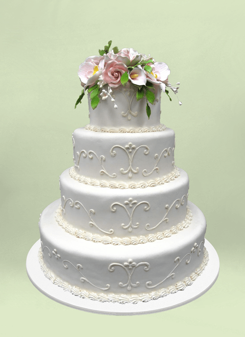 Photo: white cake with scroll pattern with fondant flowers overflowing top tier